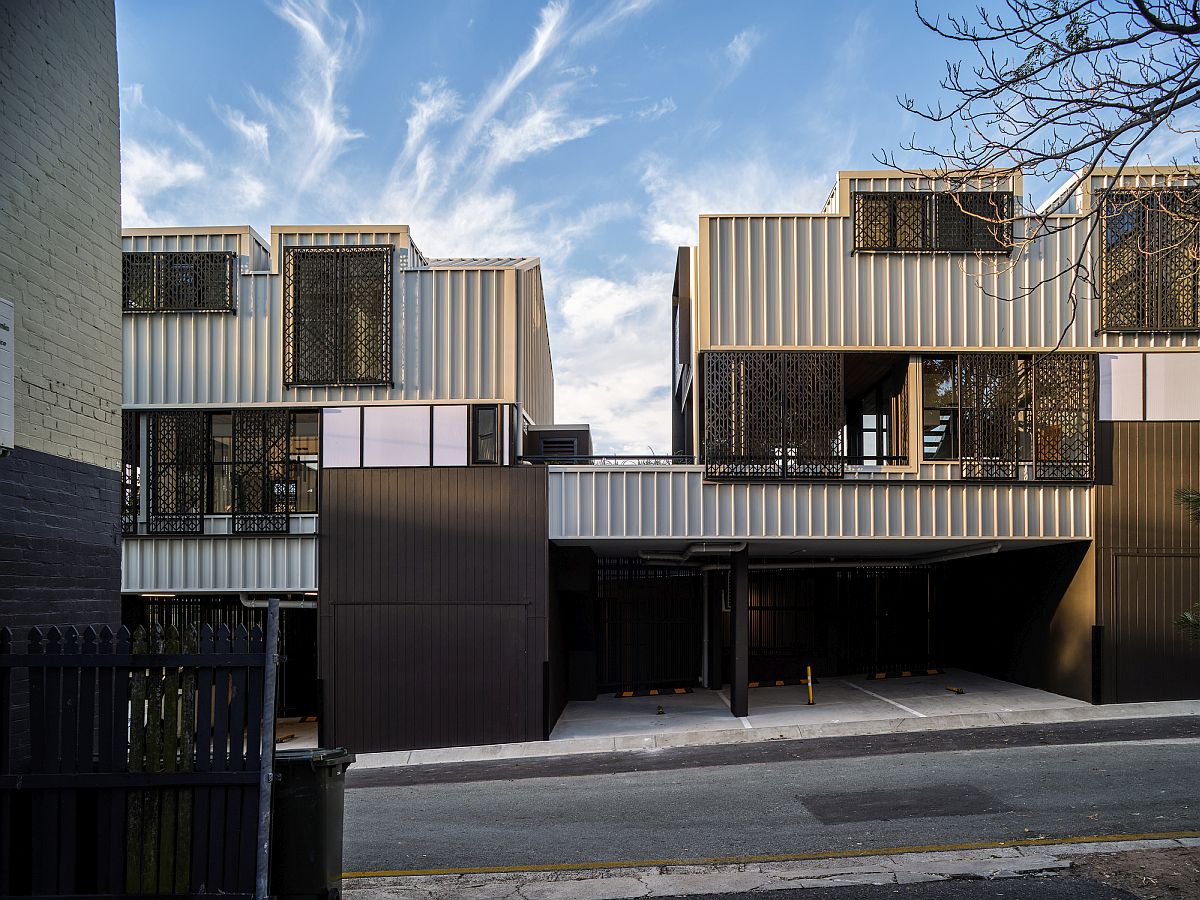 Metallic exterior of the trio of houses allows it to blend into the edgy streetscape