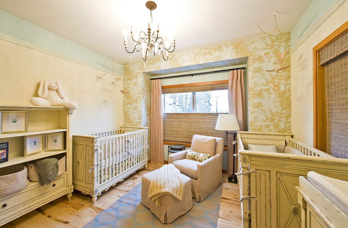 Nursery in mellow yellow with whimsical, tree-patterned wallpaper in the backdrop that is eye-catching