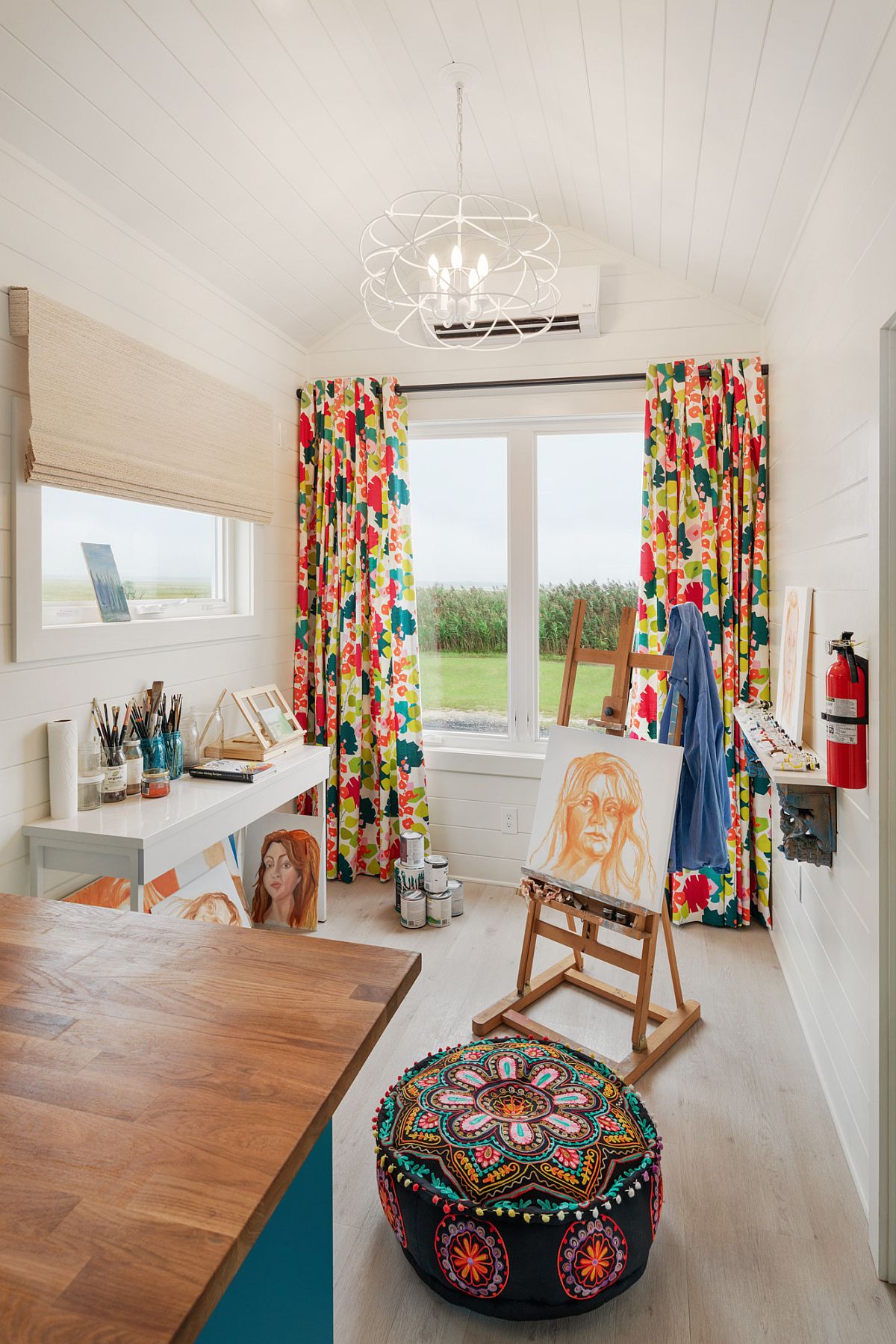 Pattern-filled drapes and ottoman add color to this small home office in neutral hues