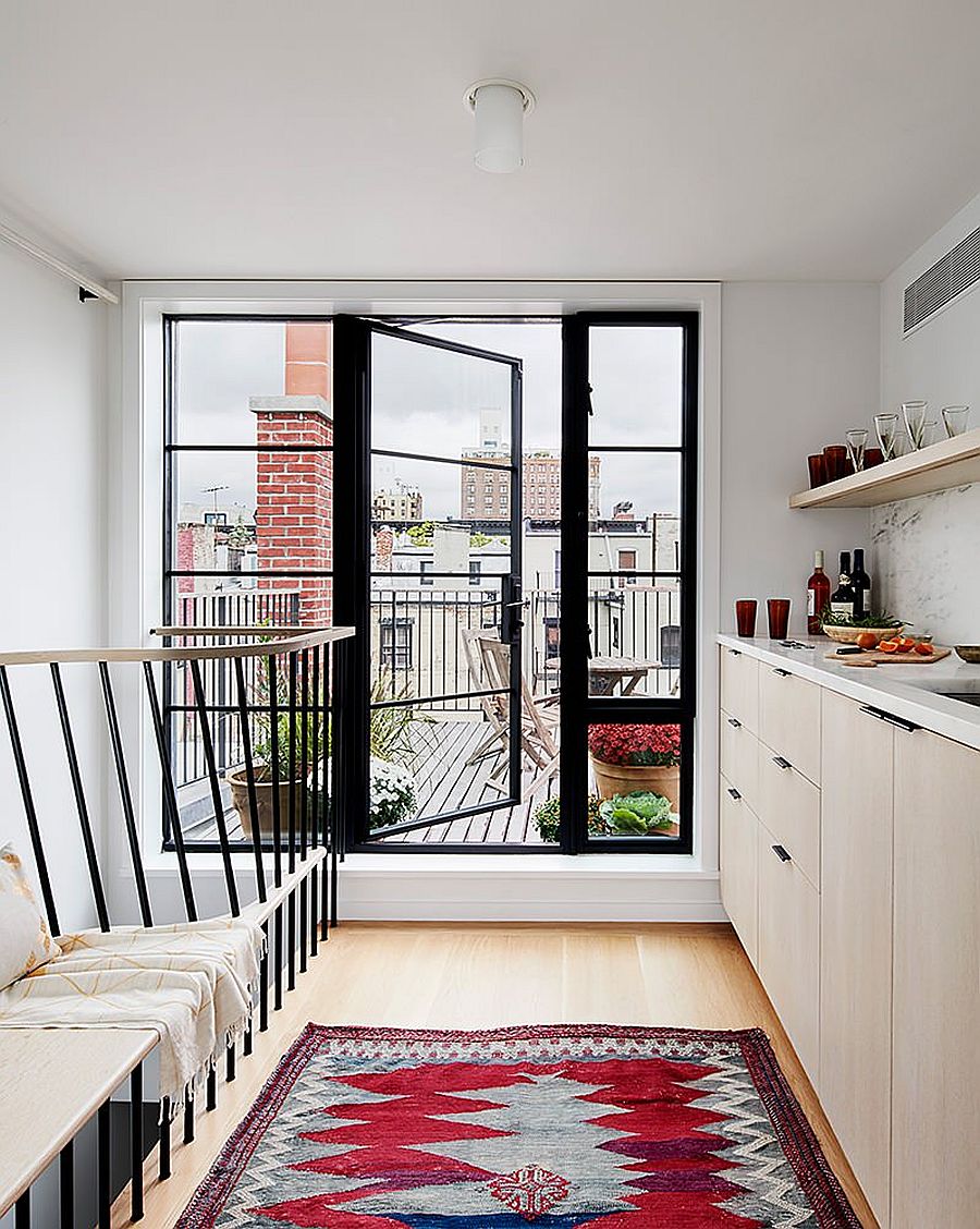 Rug in red brings a bright splash of color to this kitchen in white inside classic NYC townhouse