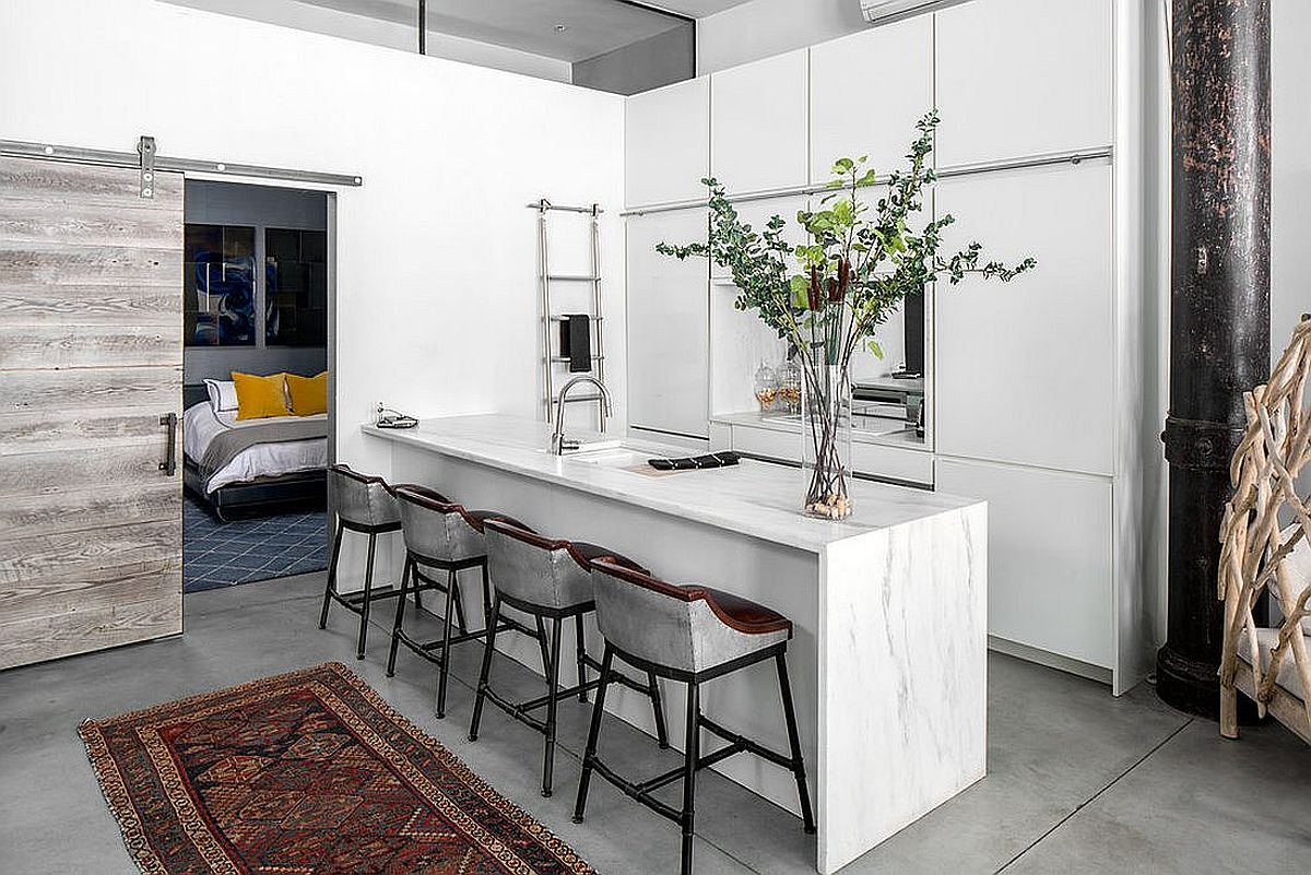 Sliding barn door connects the elegant little kitchen with the bedroom next to it