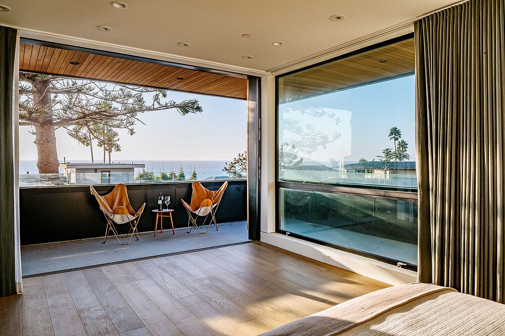 Small balcony and glass walls provide gorgeous view of the distant ocean from the bedroom