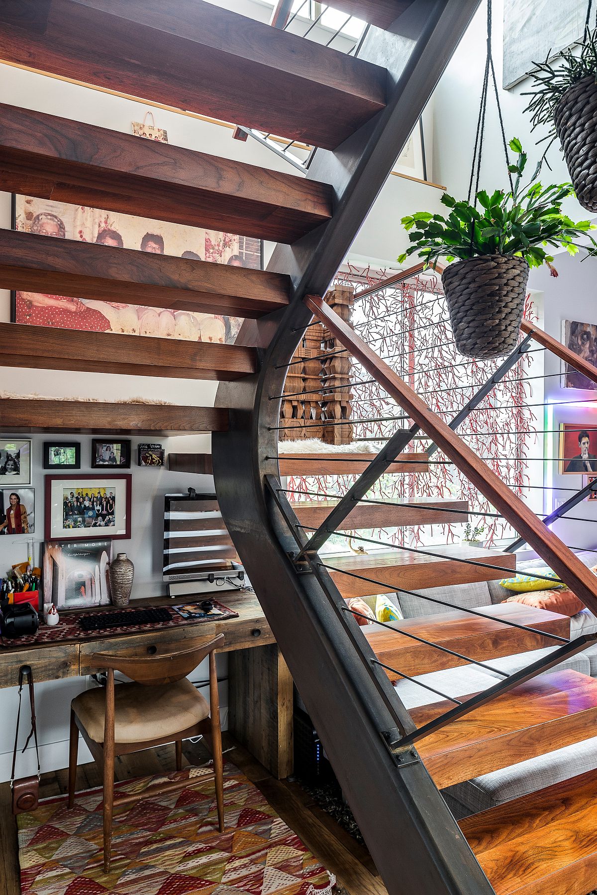 Small eclectic workspace under the staircase crafted using a simple wooden desk