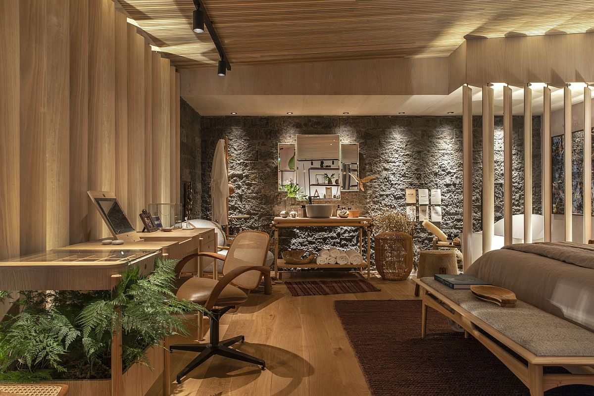 Smart lighting, stone wall, wooden finsihes and natural textures shape this lovely bedroom with home workspace