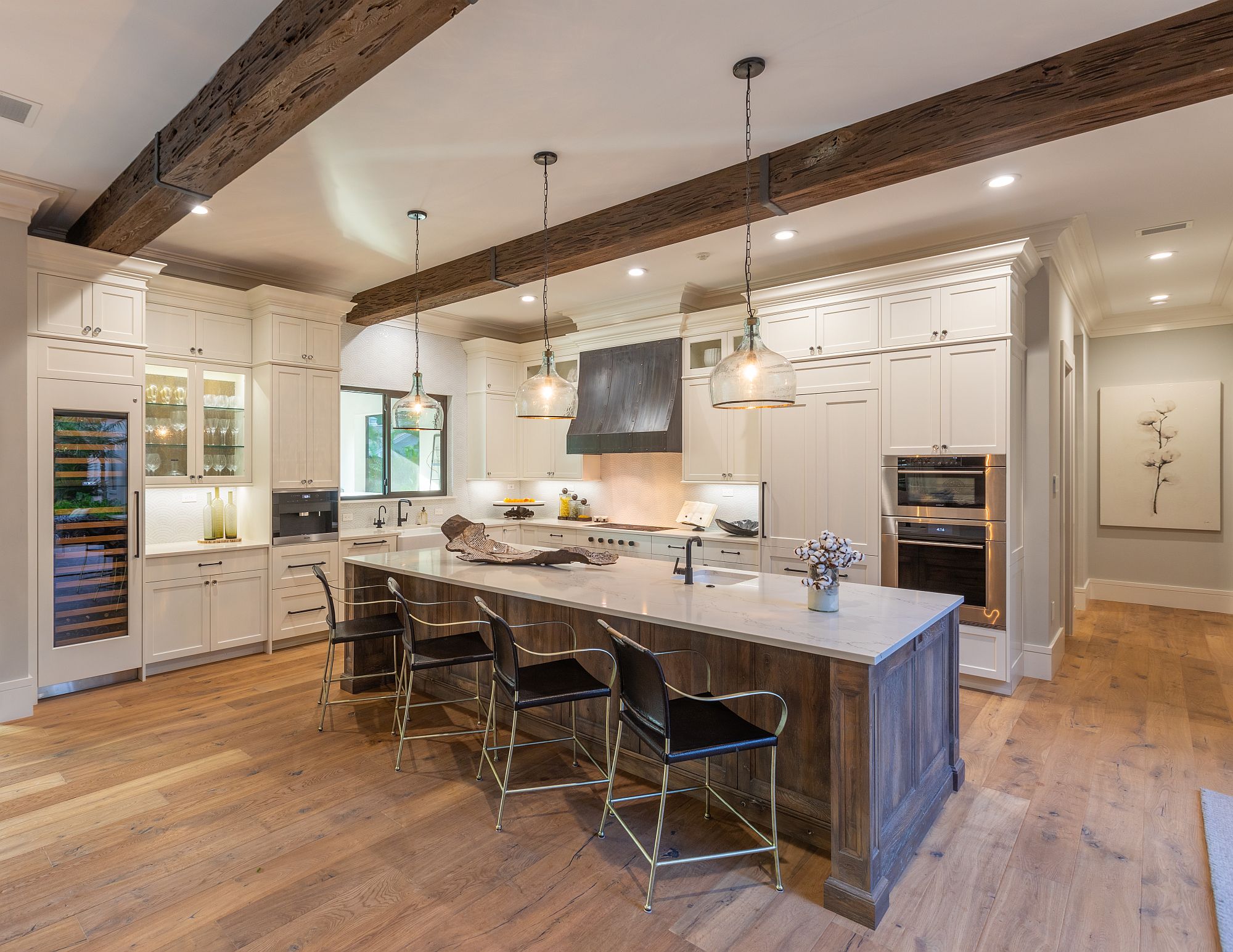 Spacious wood and white kitchen of the house with wooden ceiling beam and ample natural light