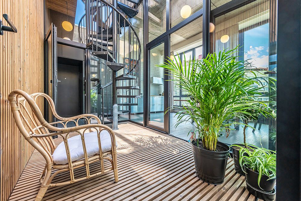 Spiral staircase connects the studio space on the lower level with the lovely modern-industrial apartment above