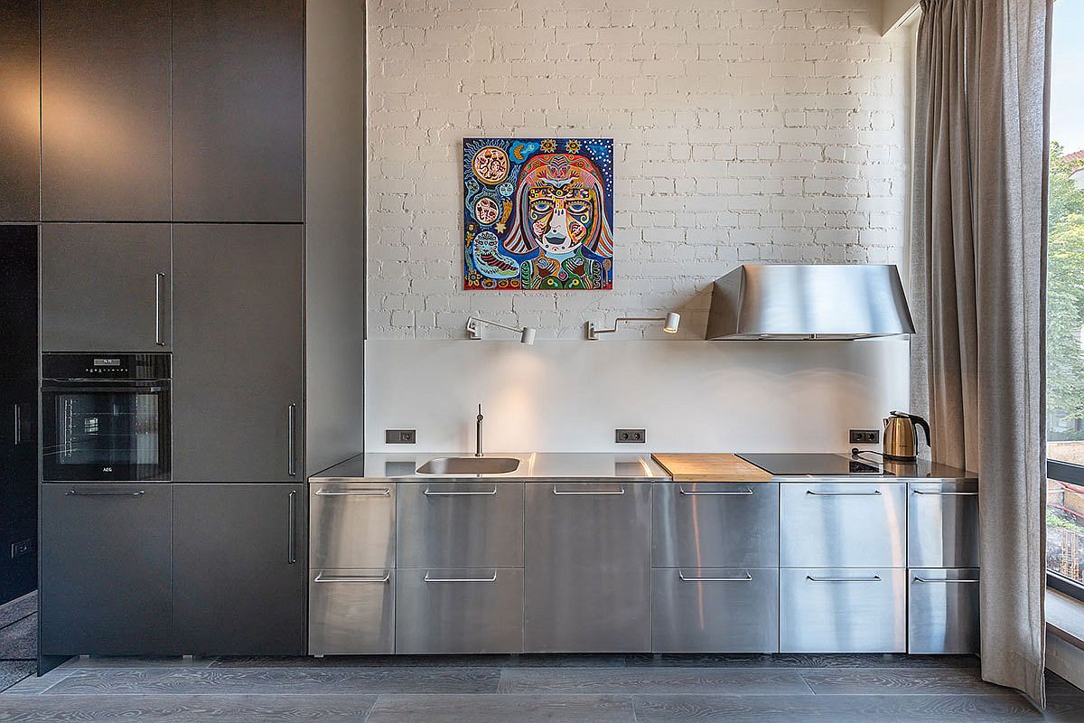 Stainless steel appliances and cabinets bring metallic gloss to the kitchen with white brick wall