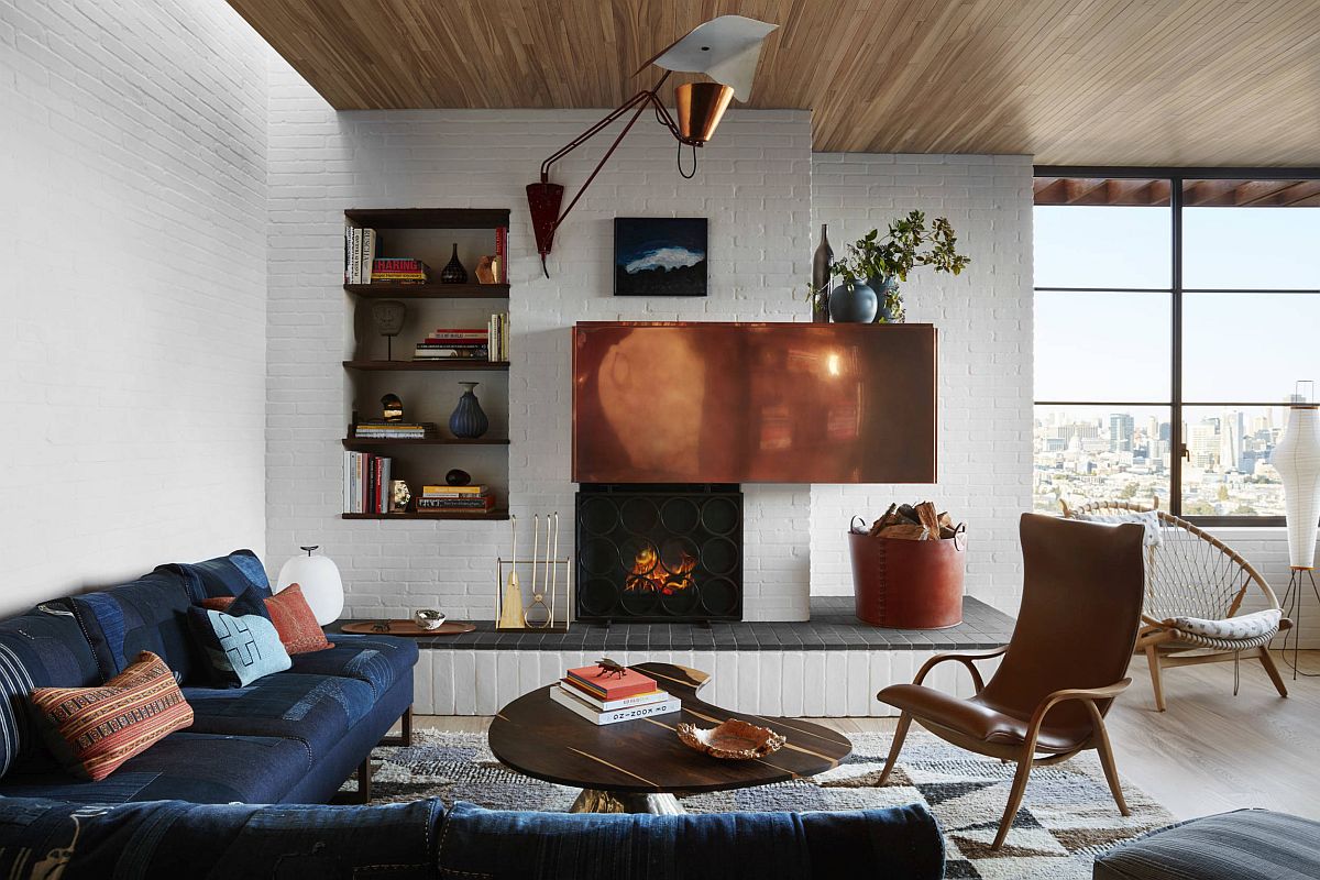 Whitewashed brick walls coupled with lovely wooden ceiling and large glass windows inside the modern living room