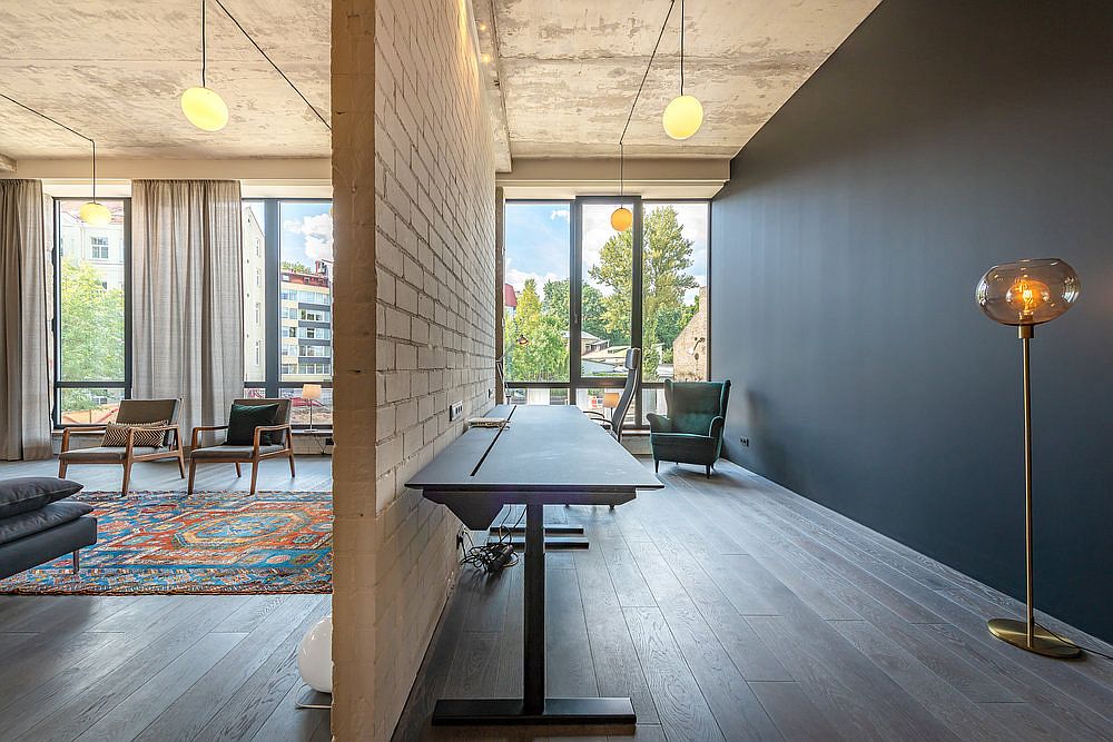 Workspace with polished dark gray walls adds modernity to the industrial apartment that was once a warehouse