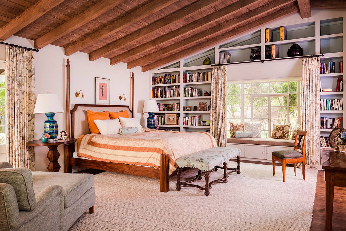 Accent pillows add orange to the spacious bedroom with traditional style