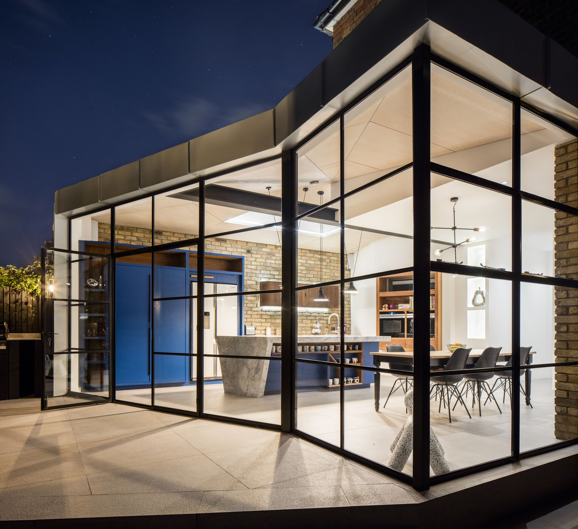 Angular roof design, zinc exterior and glass walls of the modern extension to Victorian home