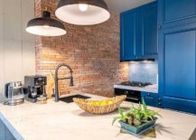 Apartment-kitchen-with-blue-cabinets-and-exposed-brick-wall-section-along-with-dashing-pendant-lights-40727-217x155