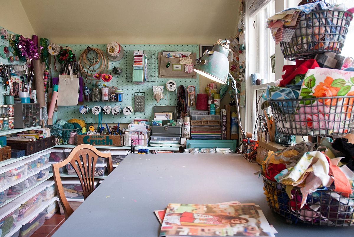 Baskets, boxes, pegboard walls and cabinets create an amazing array of storage options in this small crafts room