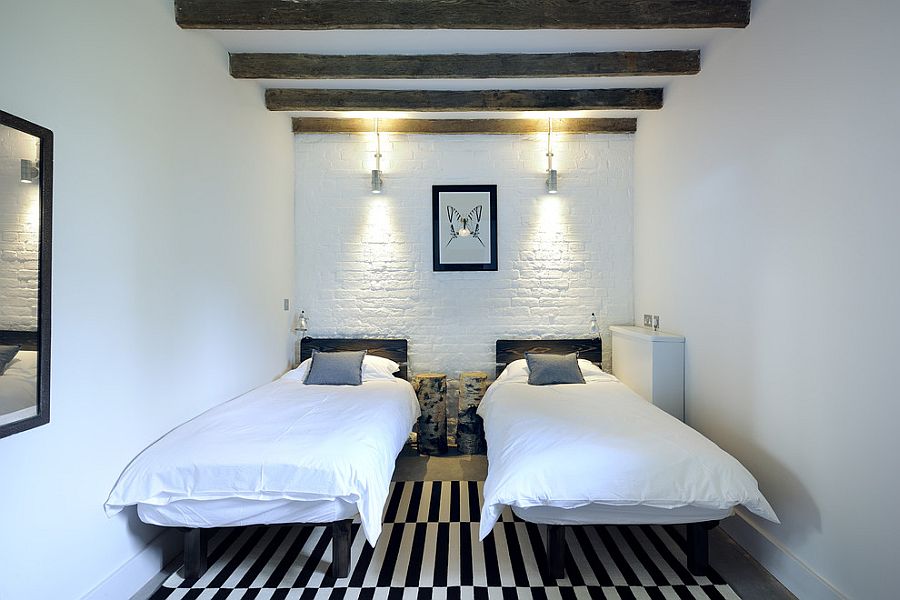 Brick wall painted white fits in with the contemporary style of the small bedroom