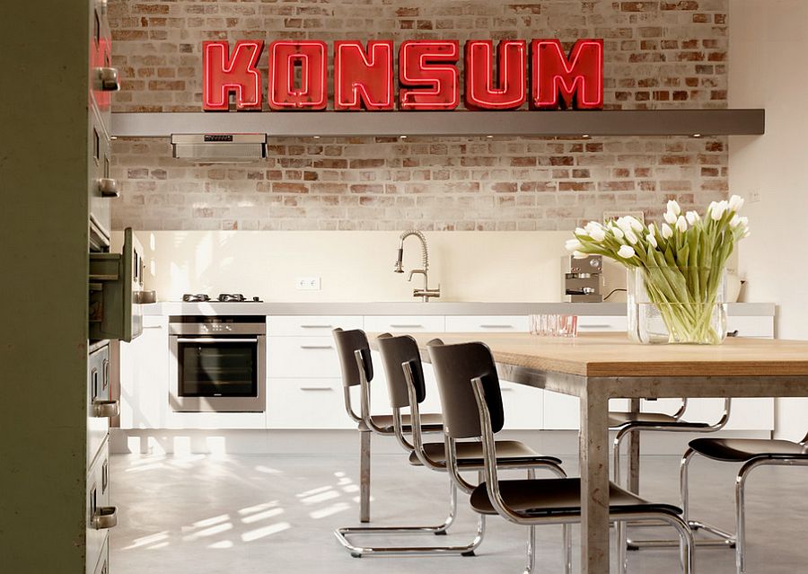 Bright neon lights steal the spotlight in this tiny industrial kitchen with whitewashed brick wall backdrop