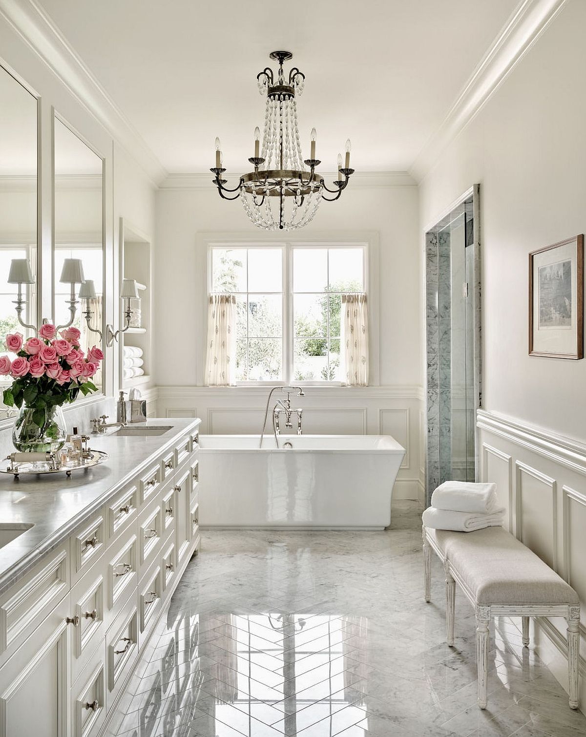 Classic bathroom in white with a beautiful black chandelier and a standalone white bathtub