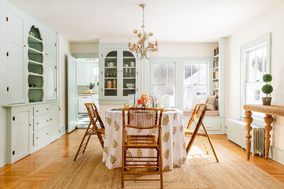 Classy shabby chic dining space with a round dining table and ample shelving in the backdrop