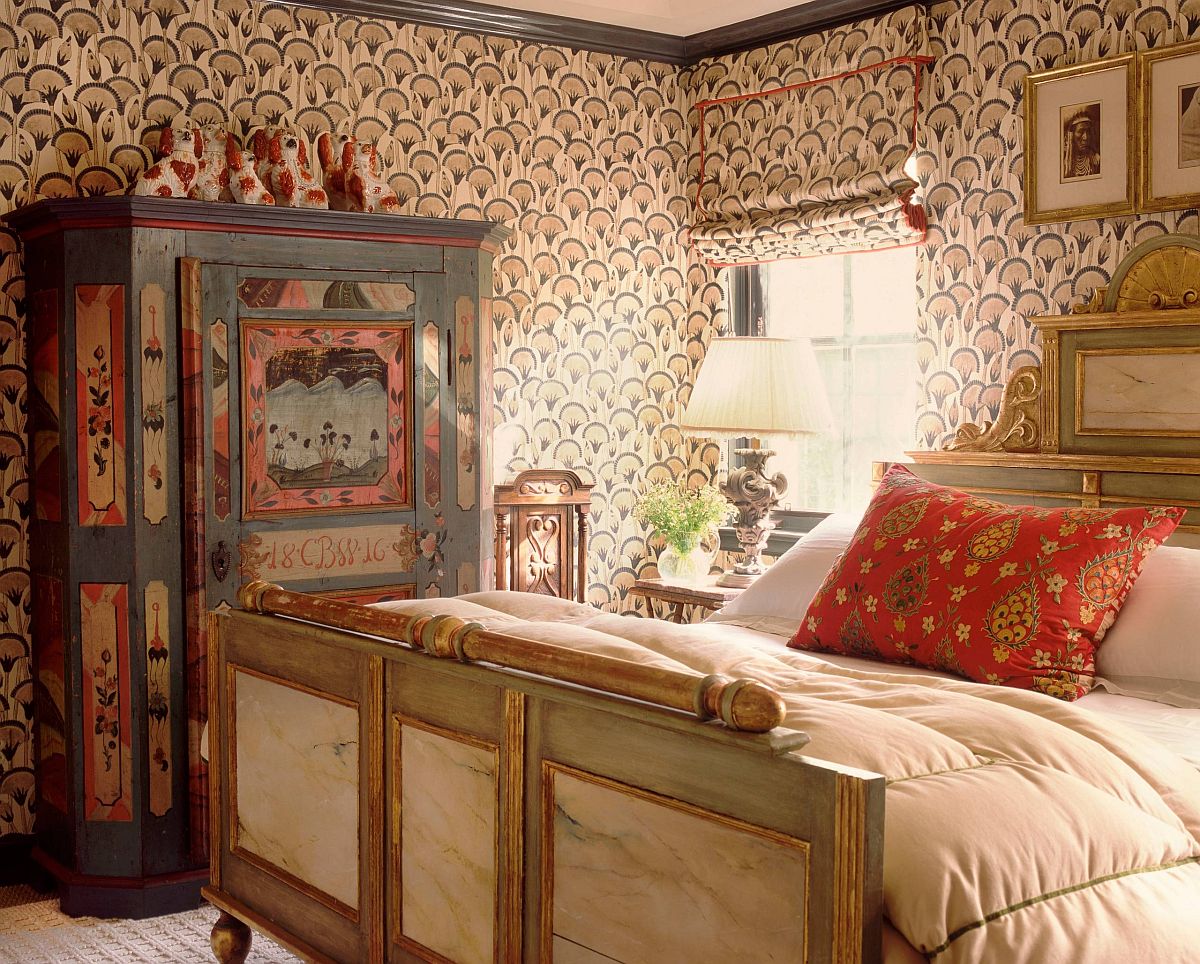 Bohemian bedroom with vintage furniture and patterned wallpaper.