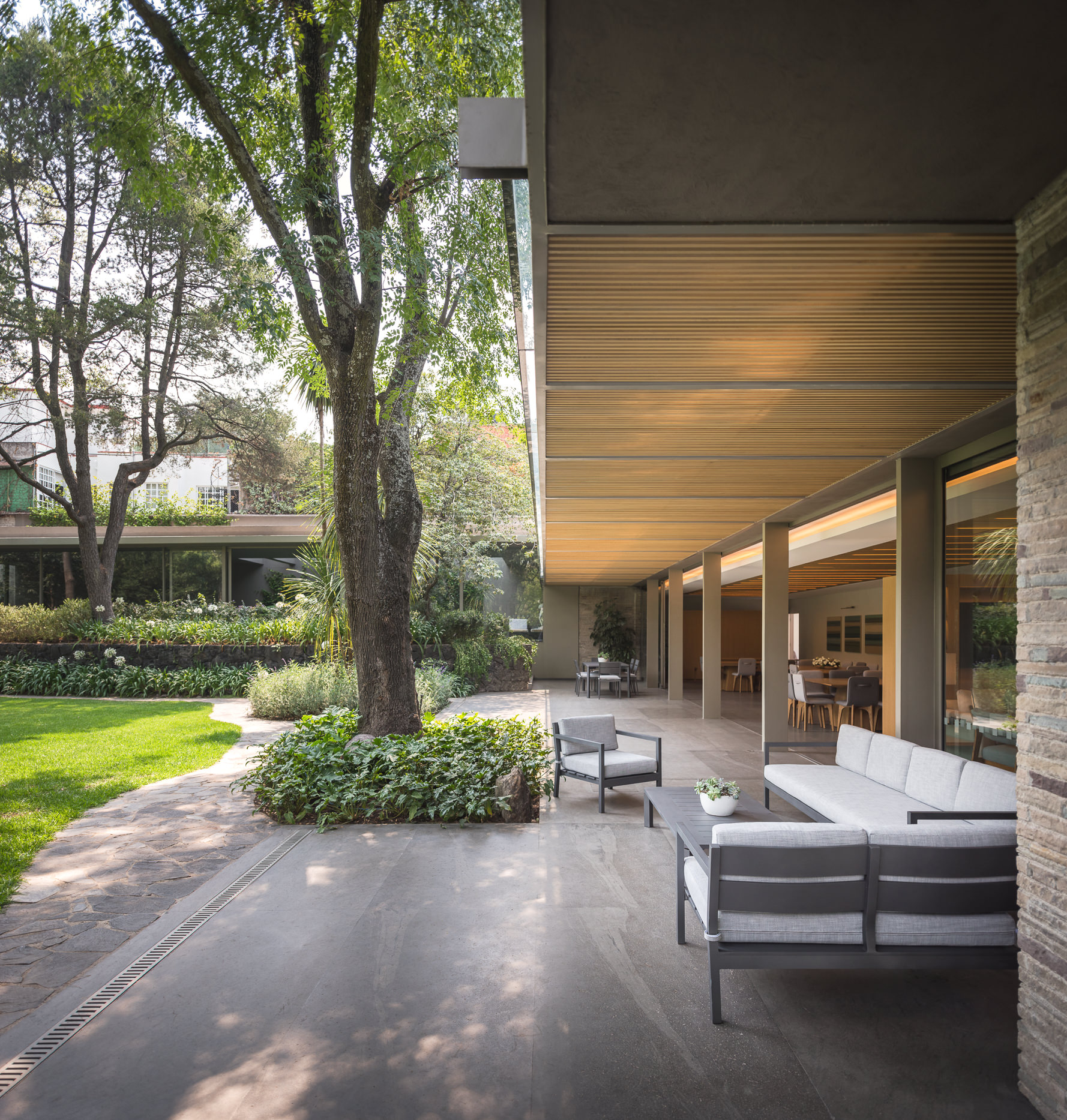 Covered outdoor areas, curated garden and lovely ambient lighting shape the landscape around the home