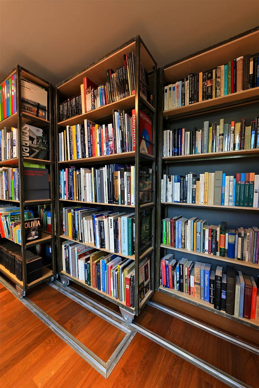 Custom wooden bookshelves on wheels can be moved around when needed!