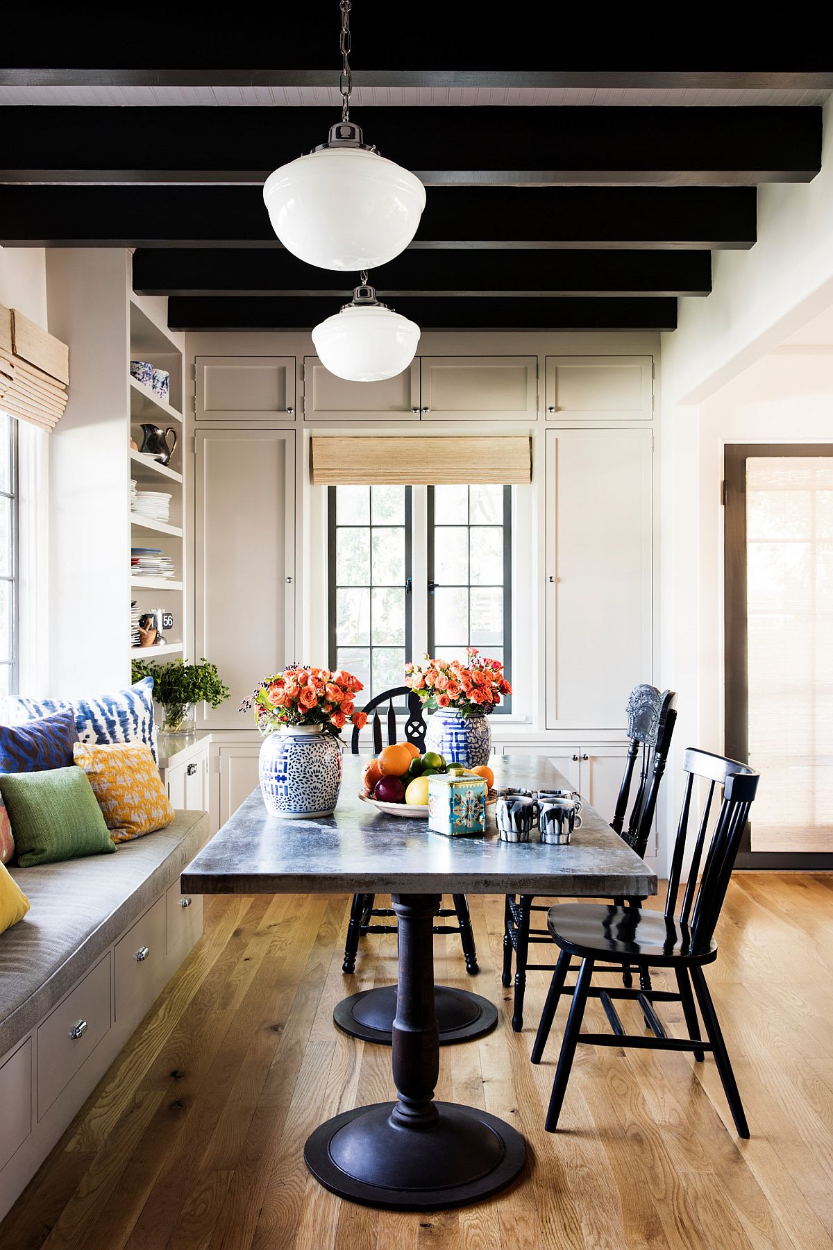 Dark ceiling beams, high ceiling and large windows give this modern Mediterranean dining room a unique appeal