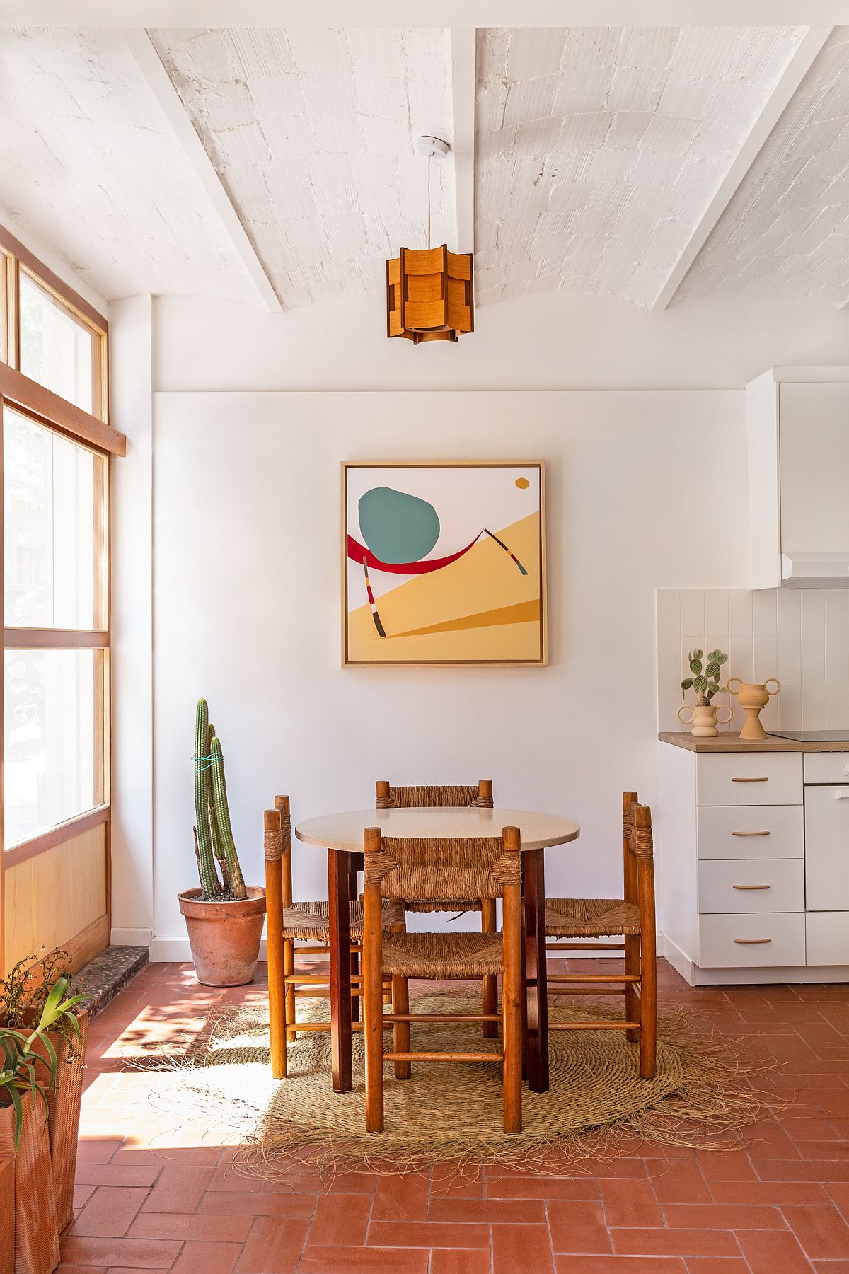 Delightful little dining room with terracotta floor tiles veers more towards modern than Mediterranean