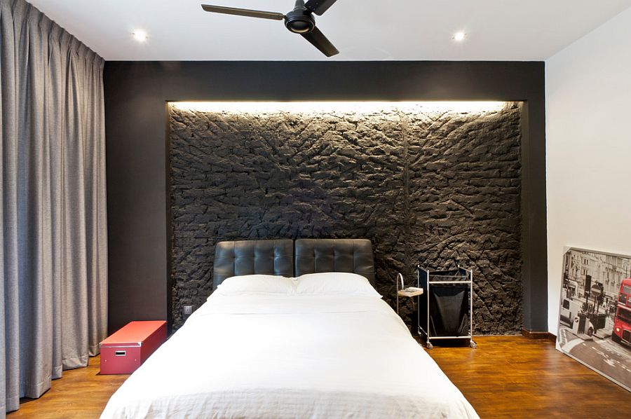 Exposed brick wall is painted gray in this modern bedroom