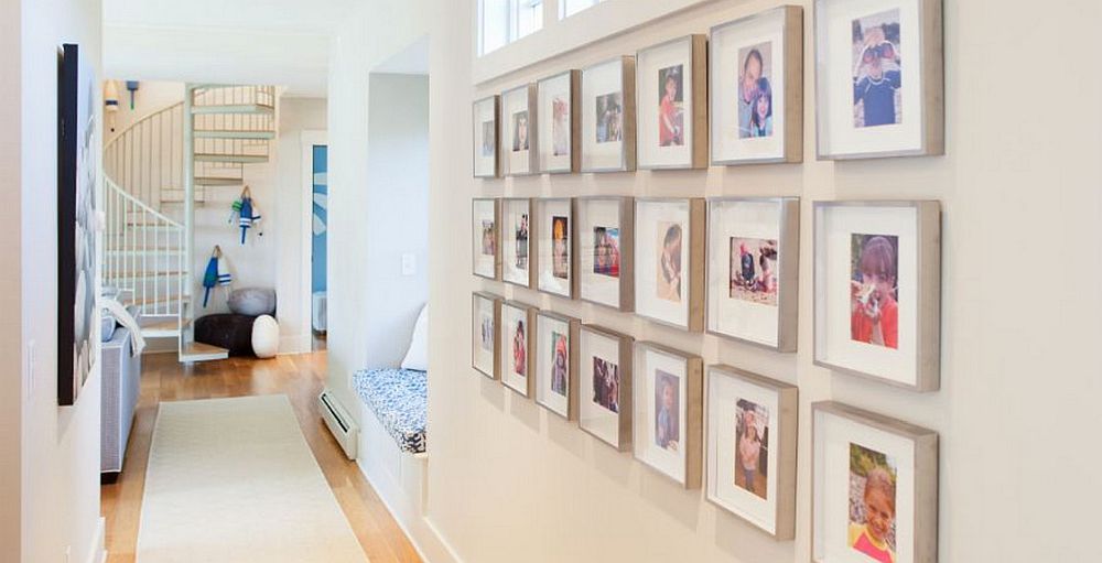 Framed personal photographs used to decorate the white becah style hallway