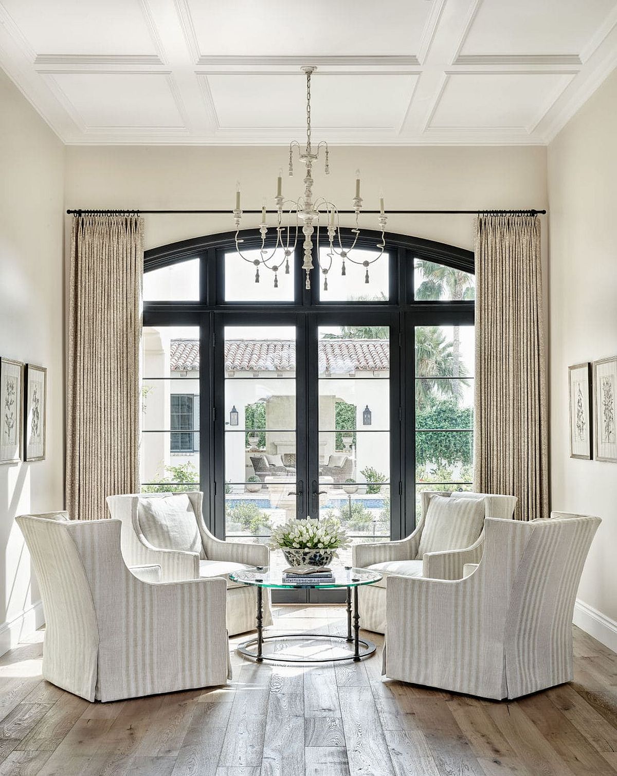 Gorgeous sitting room in white with ample natural light and a window that shapes the backdrop