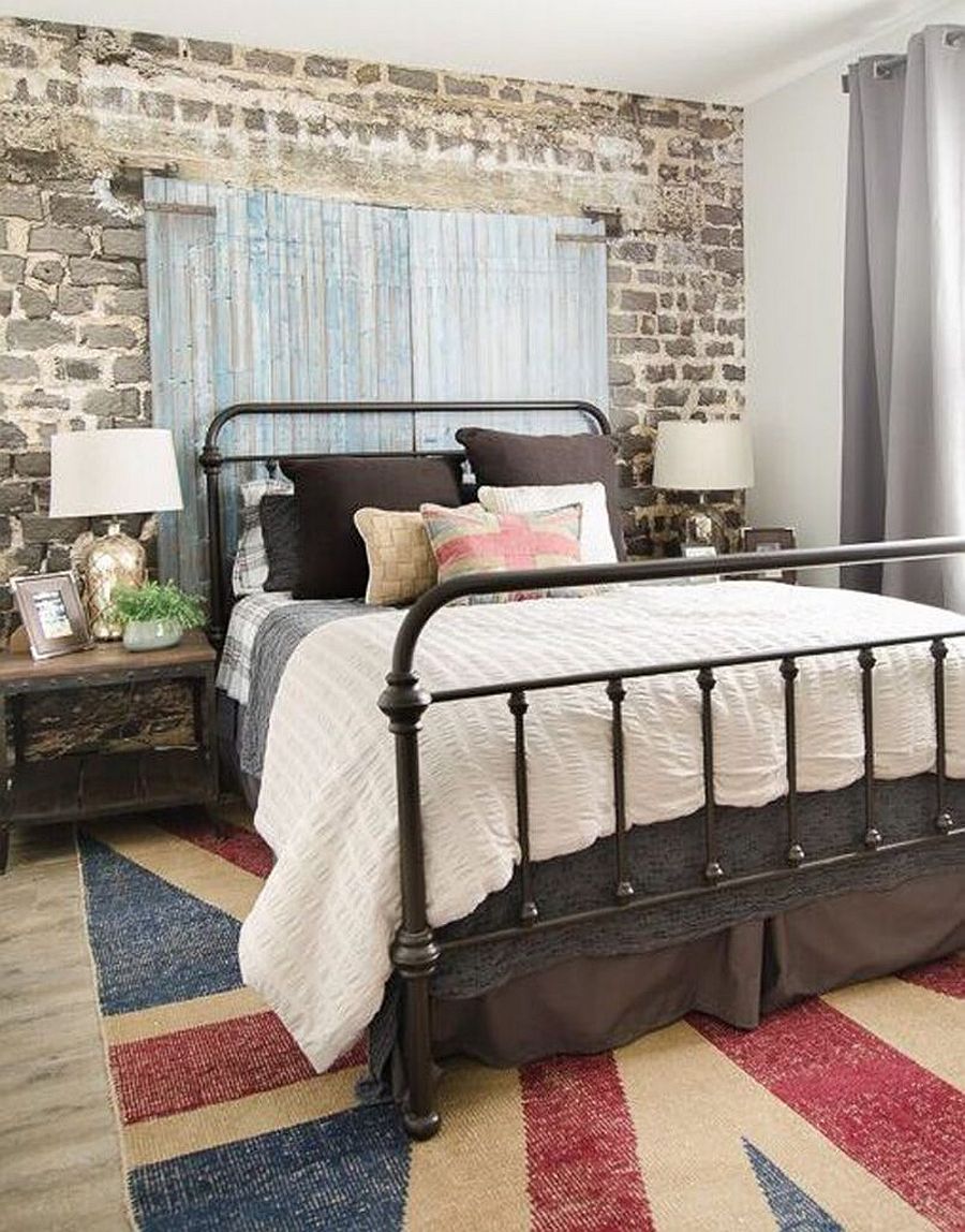 Guest bedroom with wallpapered backdrop that brings brick wall and barn door image to the space