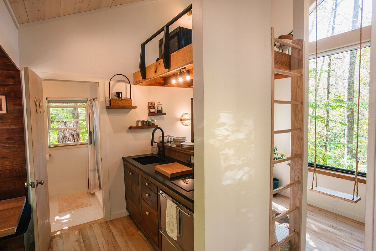 Kitchen with loft level reding space abve inside the small wooden cabin