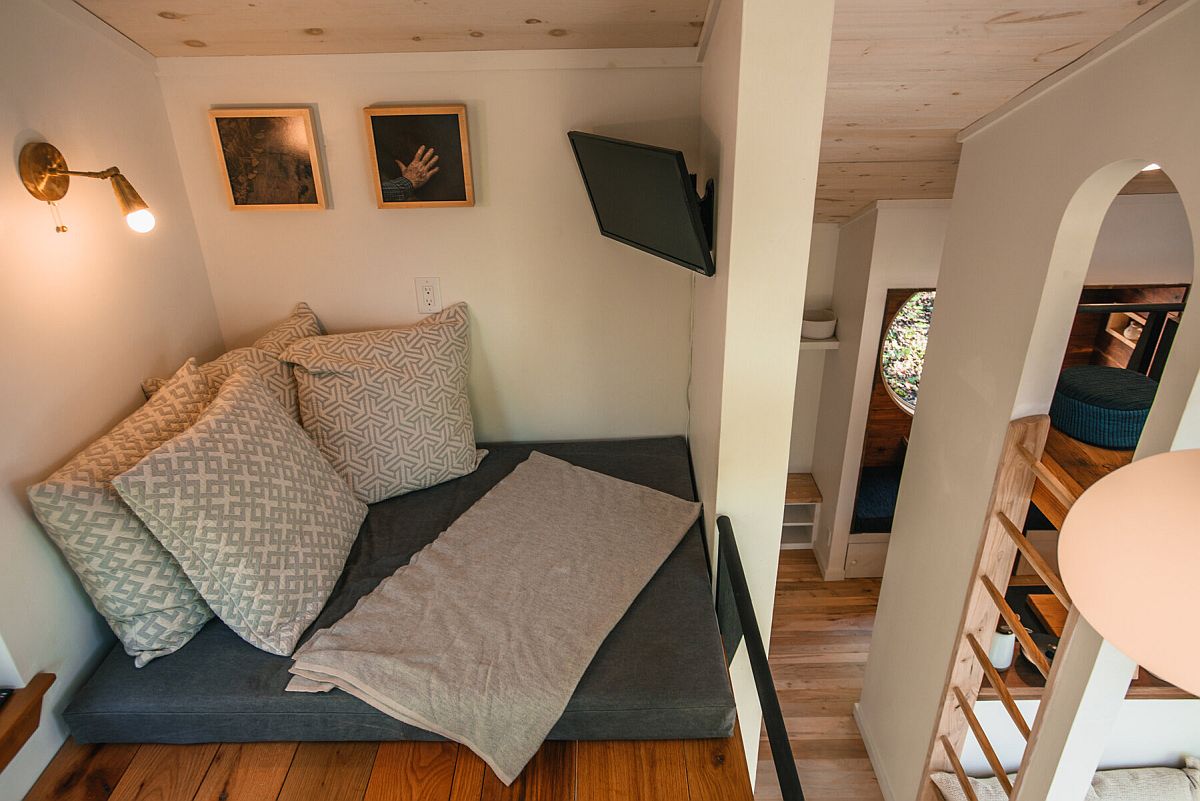 Loft level reading nook of the cabin with simple lighting and small relaxing area