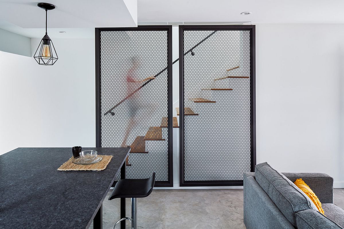 Metallic mesh structures hide the staircase leading to the upper level of the house