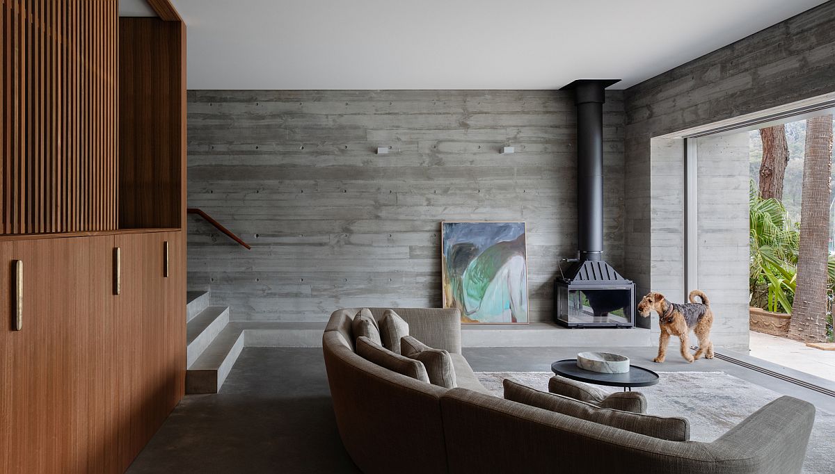 Minimal living room of the Sydney house with a comfortable couch and a corner fireplace