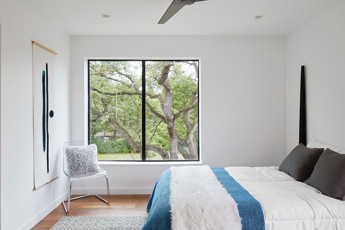 Modern bedroom in white of the Texas home with simple blue accents