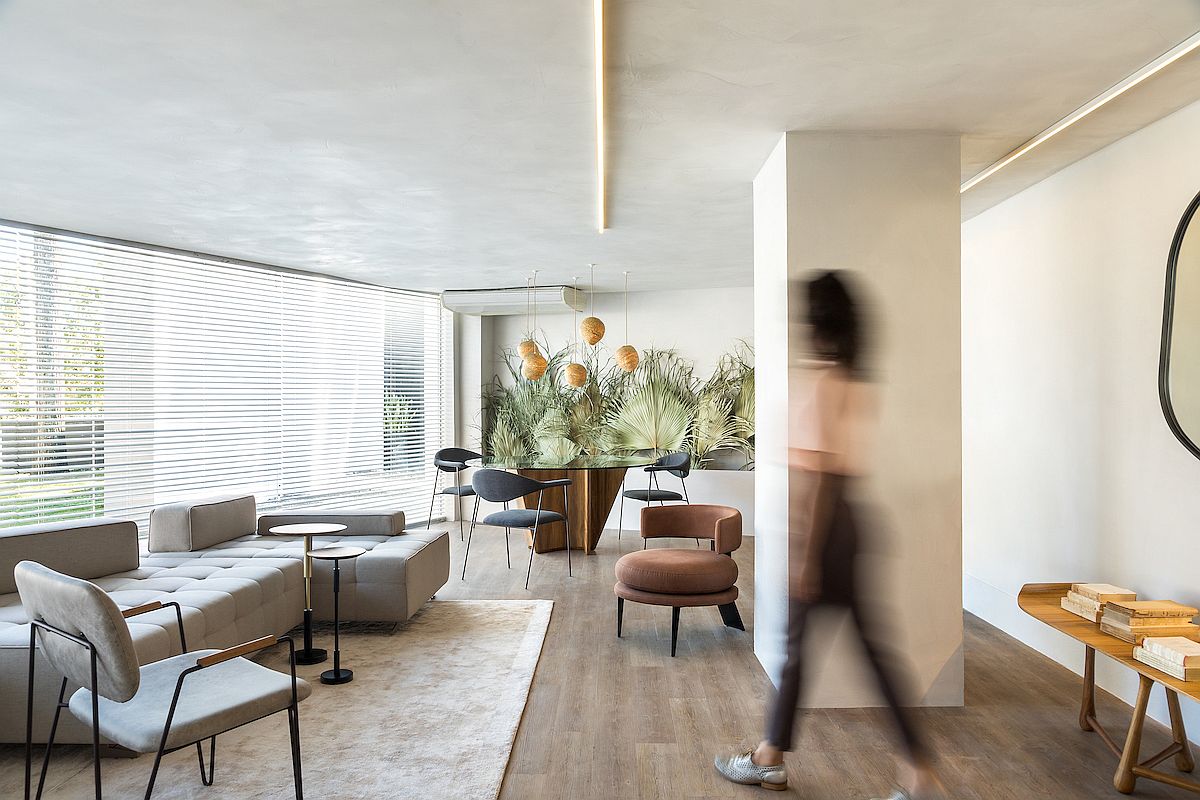 Open plan living area of the apartment with dining space that features a display of dried palm leaves