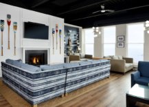 Paddles-on-the-wall-striped-couch-in-blue-and-white-and-a-cozy-fireplace-shape-the-interior-of-the-beach-club-lounge-27863-217x155