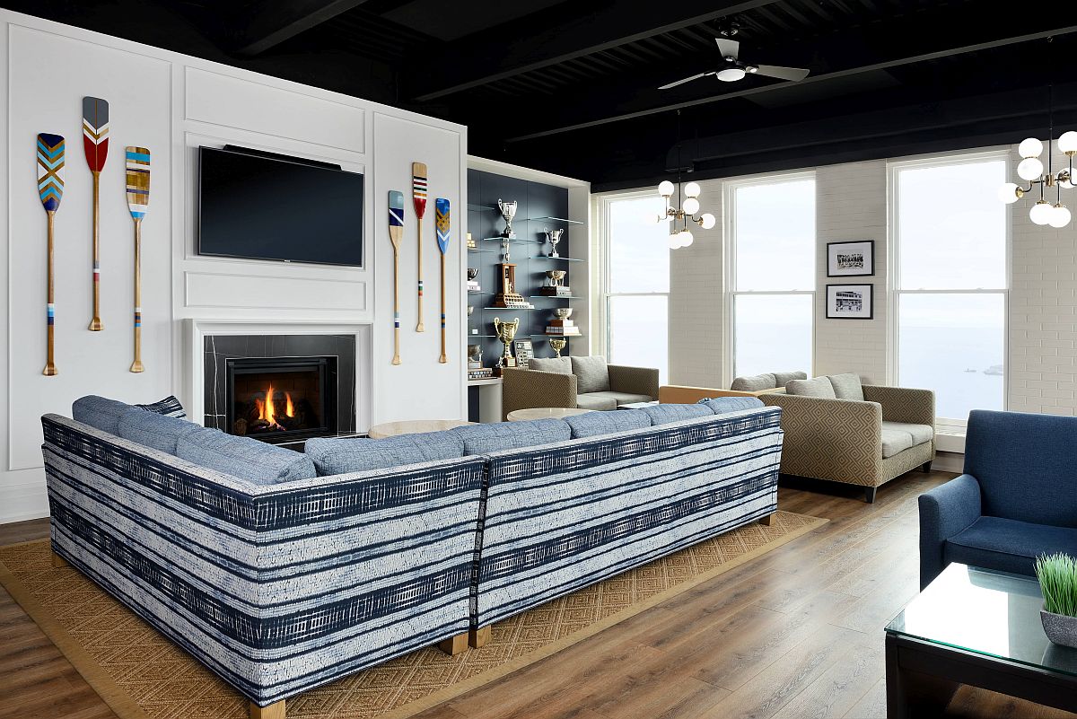 Paddles on the wall, striped couch in blue and white and a cozy fireplace shape the interior of the beach club lounge