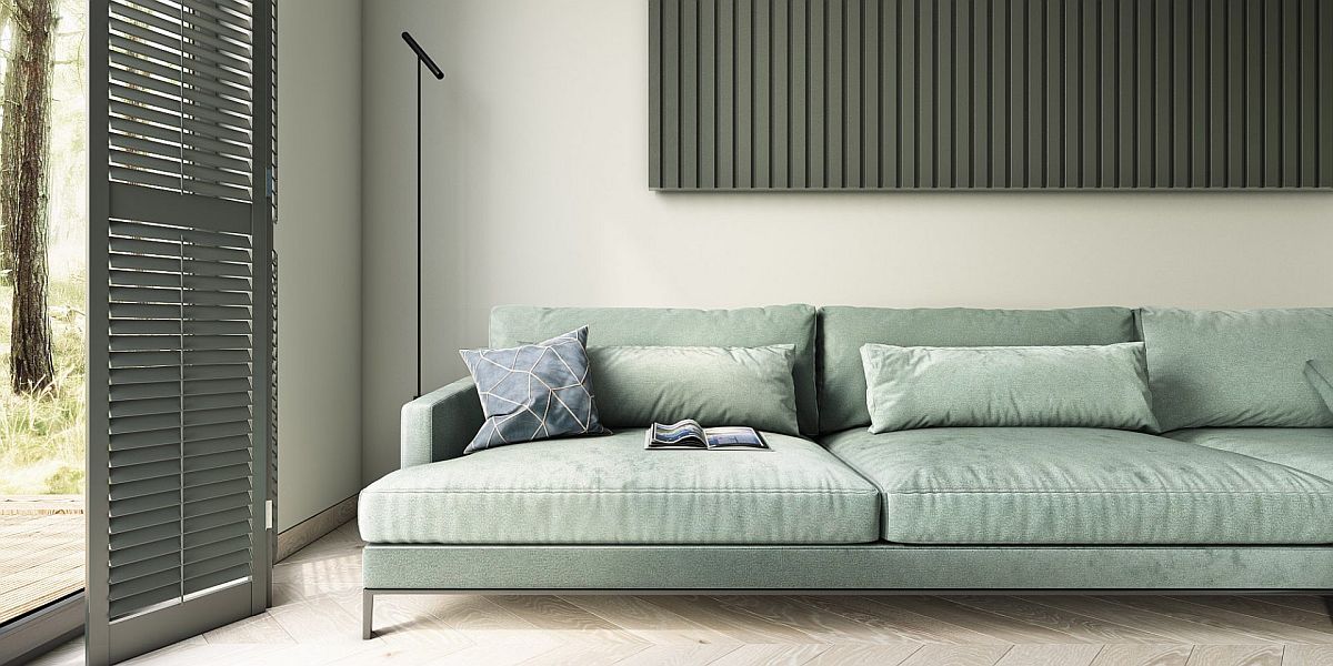 Plush light blue couch for the living room with low-slung design and a minimal floor lamp in black next to it