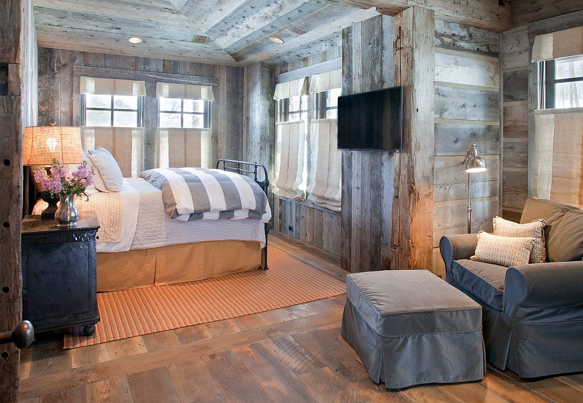 Reading nook in ths rustic bedroom is fashioned using just a floor lamp, comfy chair and ottoman