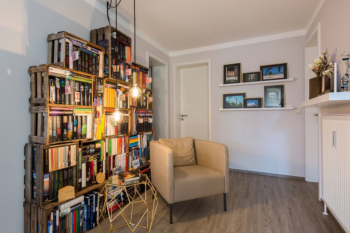 Repurposed wooden crates have been used to create a custom bookshelf in this small home library