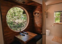 Round-window-and-wooden-walls-give-the-interior-of-the-cabin-a-cozy-and-whimsical-charm-94962-217x155