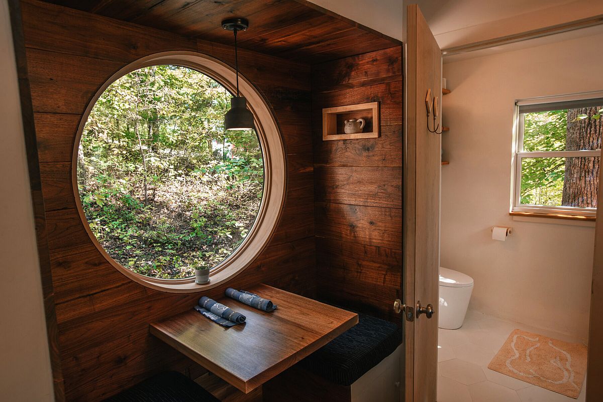 Round-window-and-wooden-walls-give-the-interior-of-the-cabin-a-cozy-and-whimsical-charm-94962