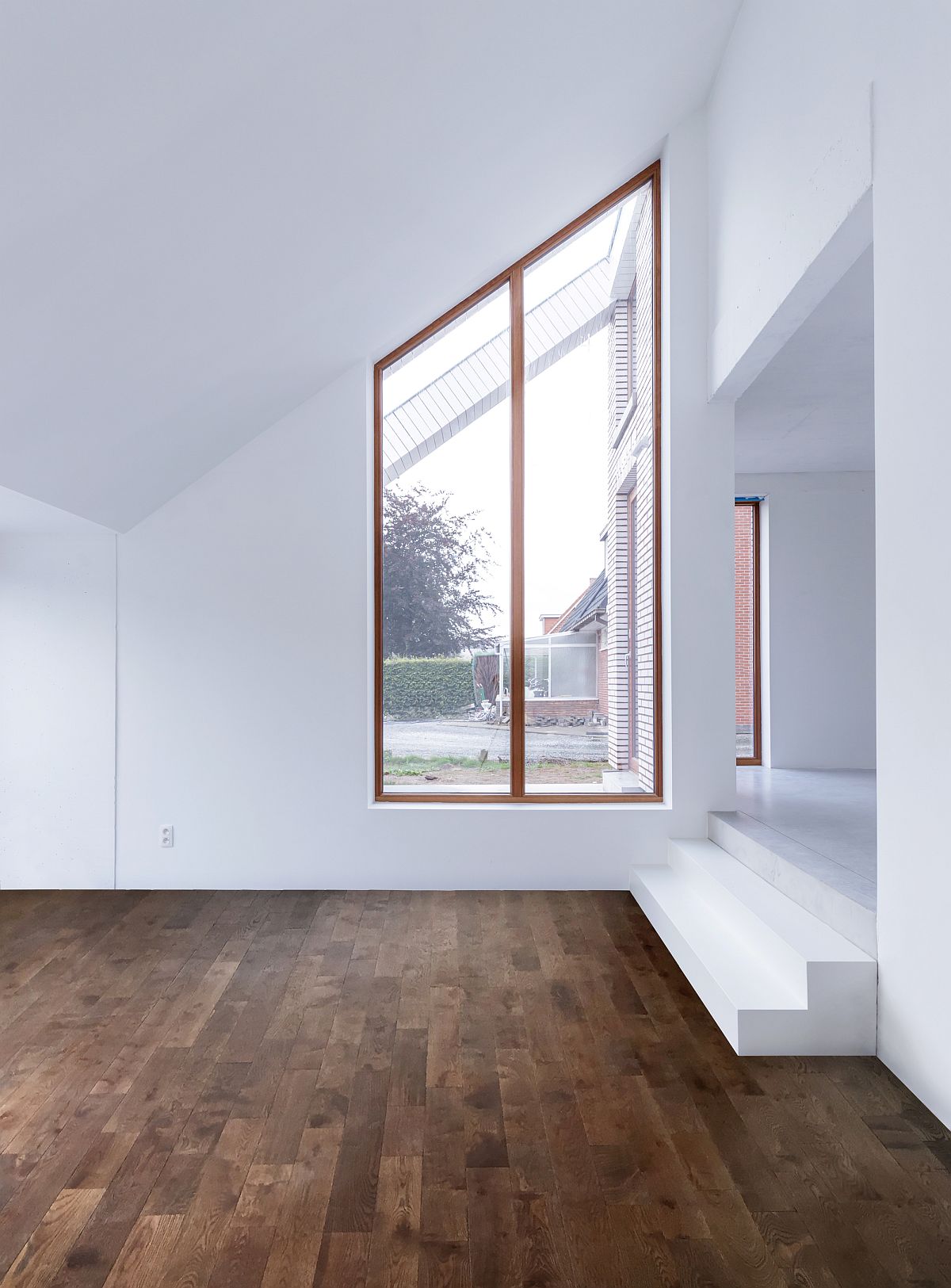 Slanting form of the roof is complemented by the shape of the window frame