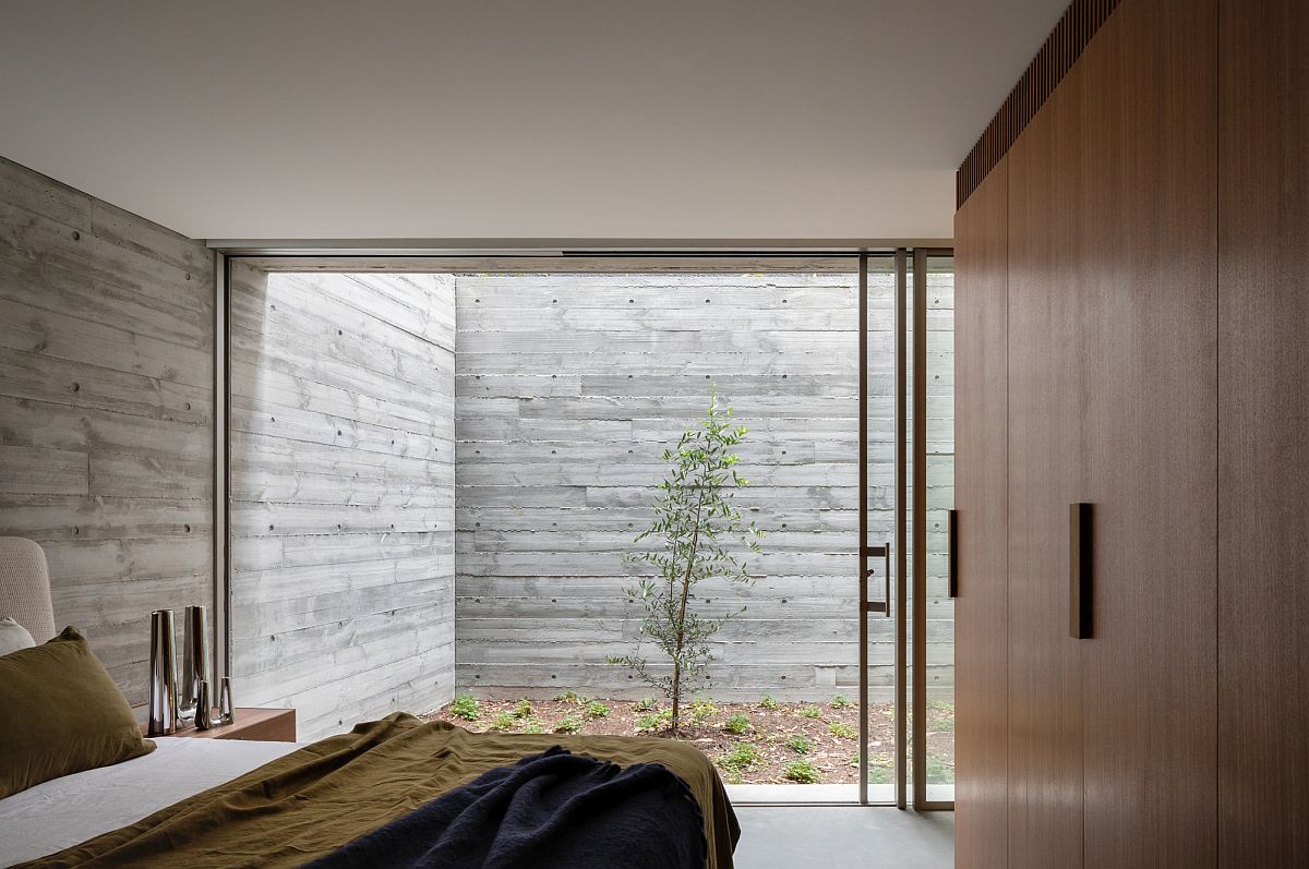 Sliding glass doors connect the bedroom and the small garden area outside