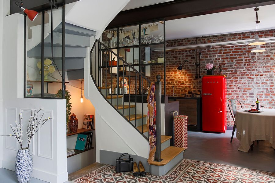 Small kitchen behind the spiral staircase inside the tiny apartment is stylish and space-savvy