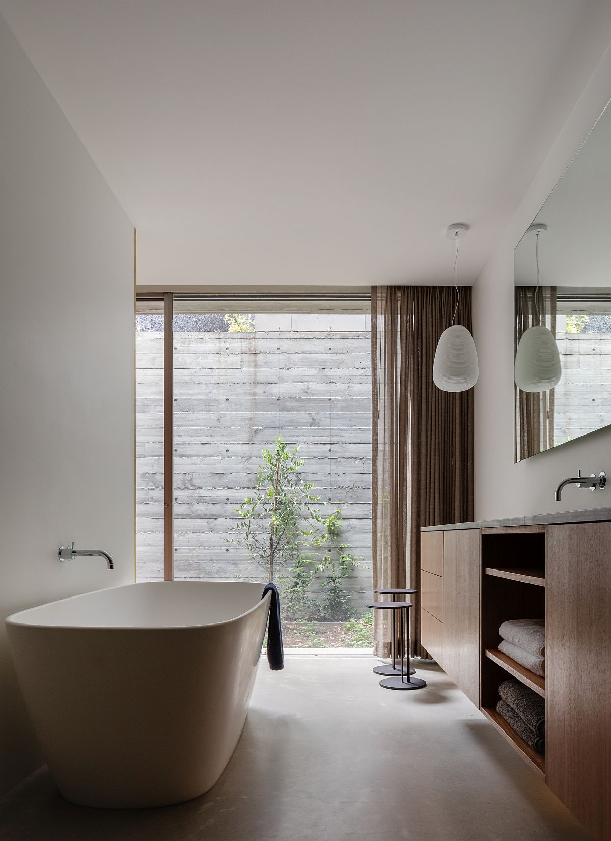Spacious contemporary bathroom with a standalone bathtub and wooden vanity