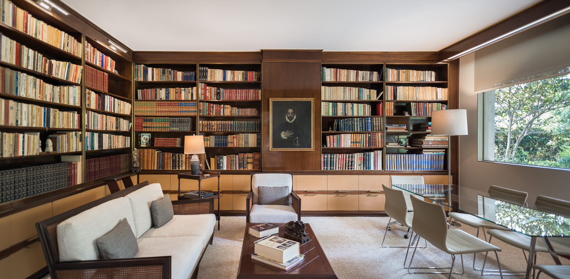 Spacious home library with glass table, chairs and multiple seating options