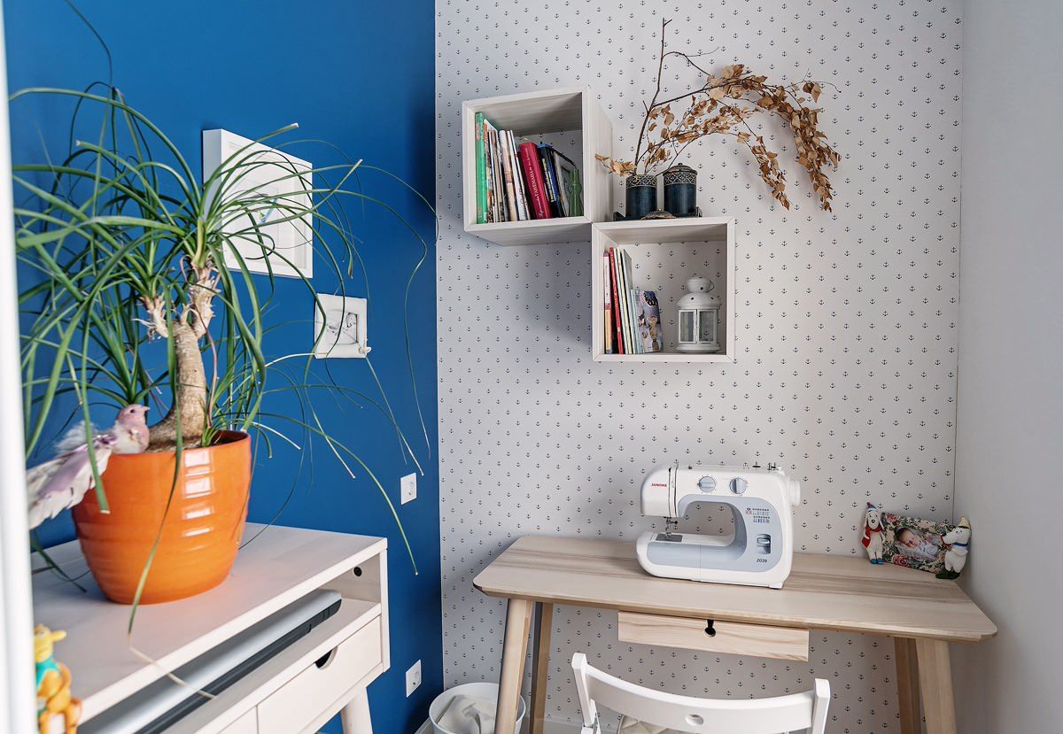 Tiny desk in the corner acts as the crafting station in this delightful little blue and white crafts room