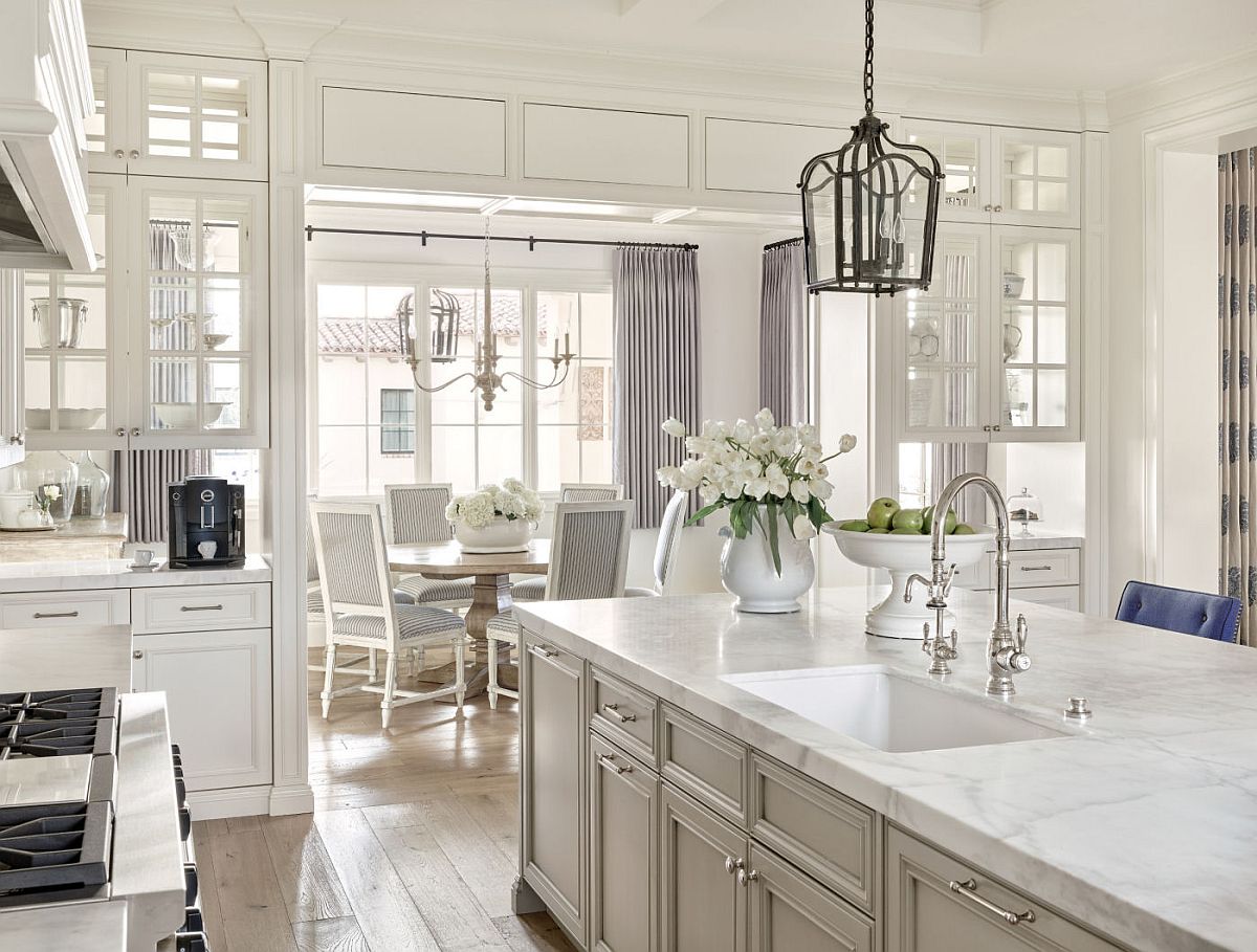 Traditional kitchen and dining are aof the remodeled home in white with gray accents and drapes